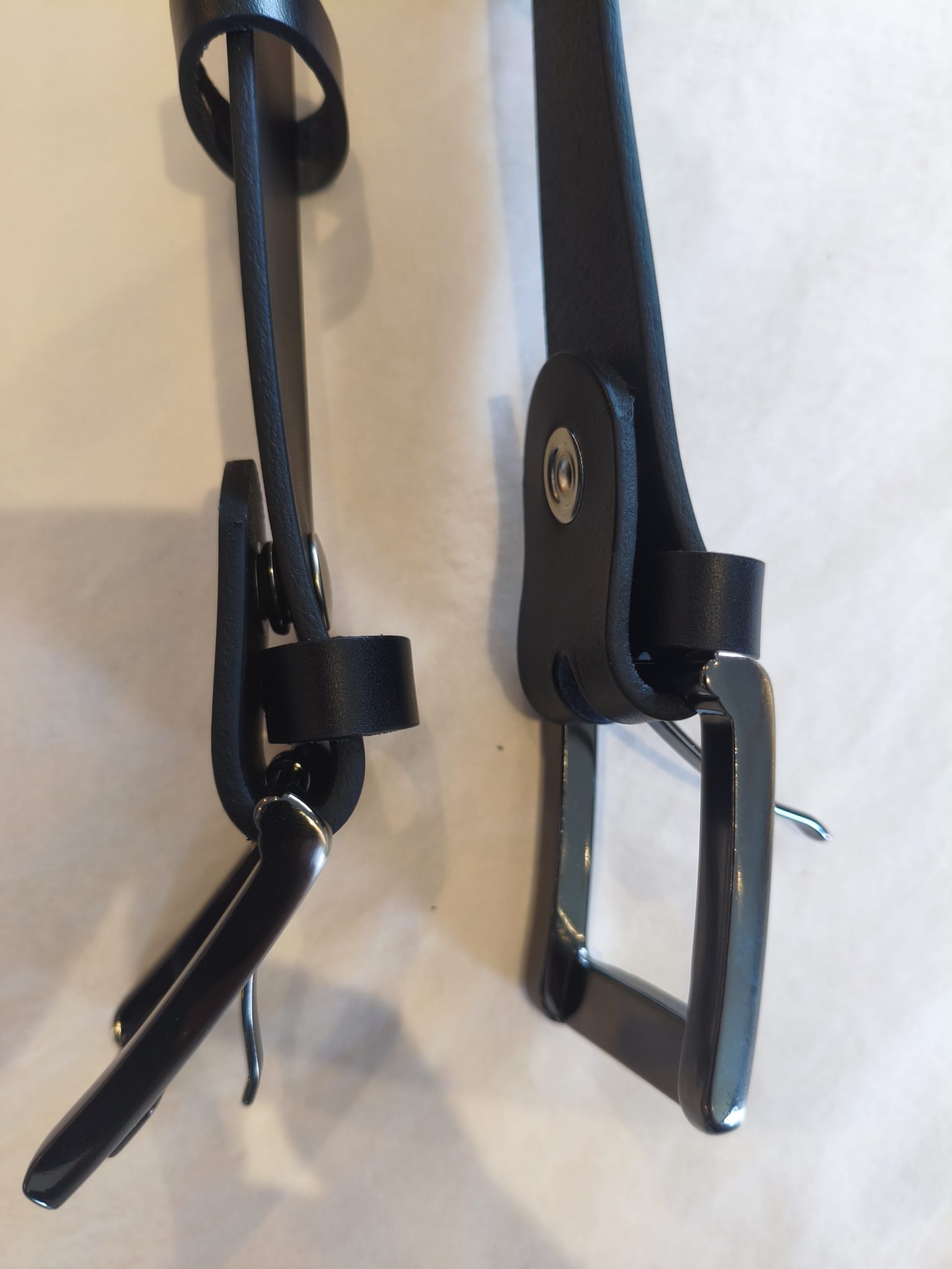 Comparaison de deux ceintures noires en cuir de collet standard et en cuir de croupon extra-épais