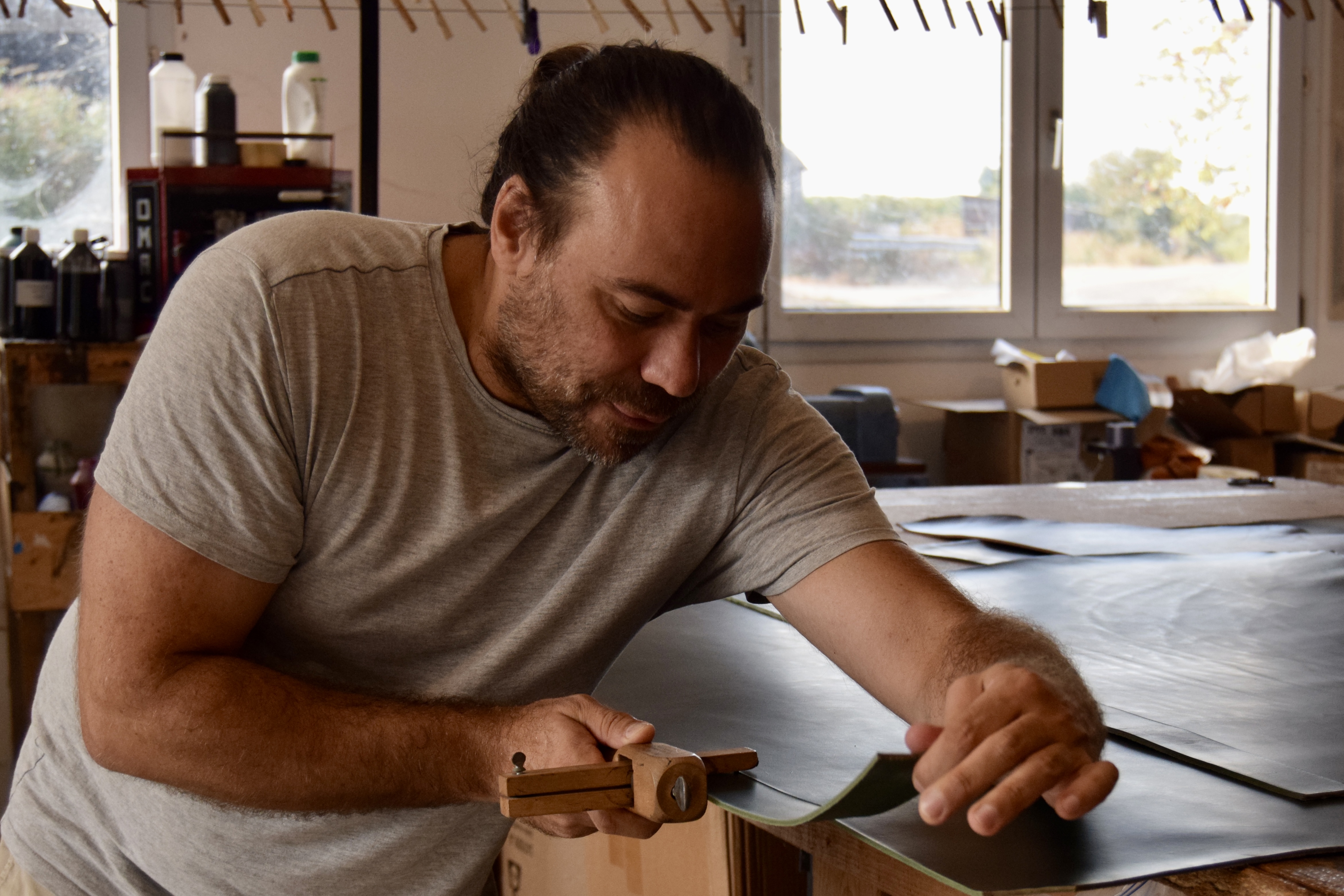 Découpe d'une longue sangle directement dans une peau de cuir pleine fleur dans l'atelier de Pornic