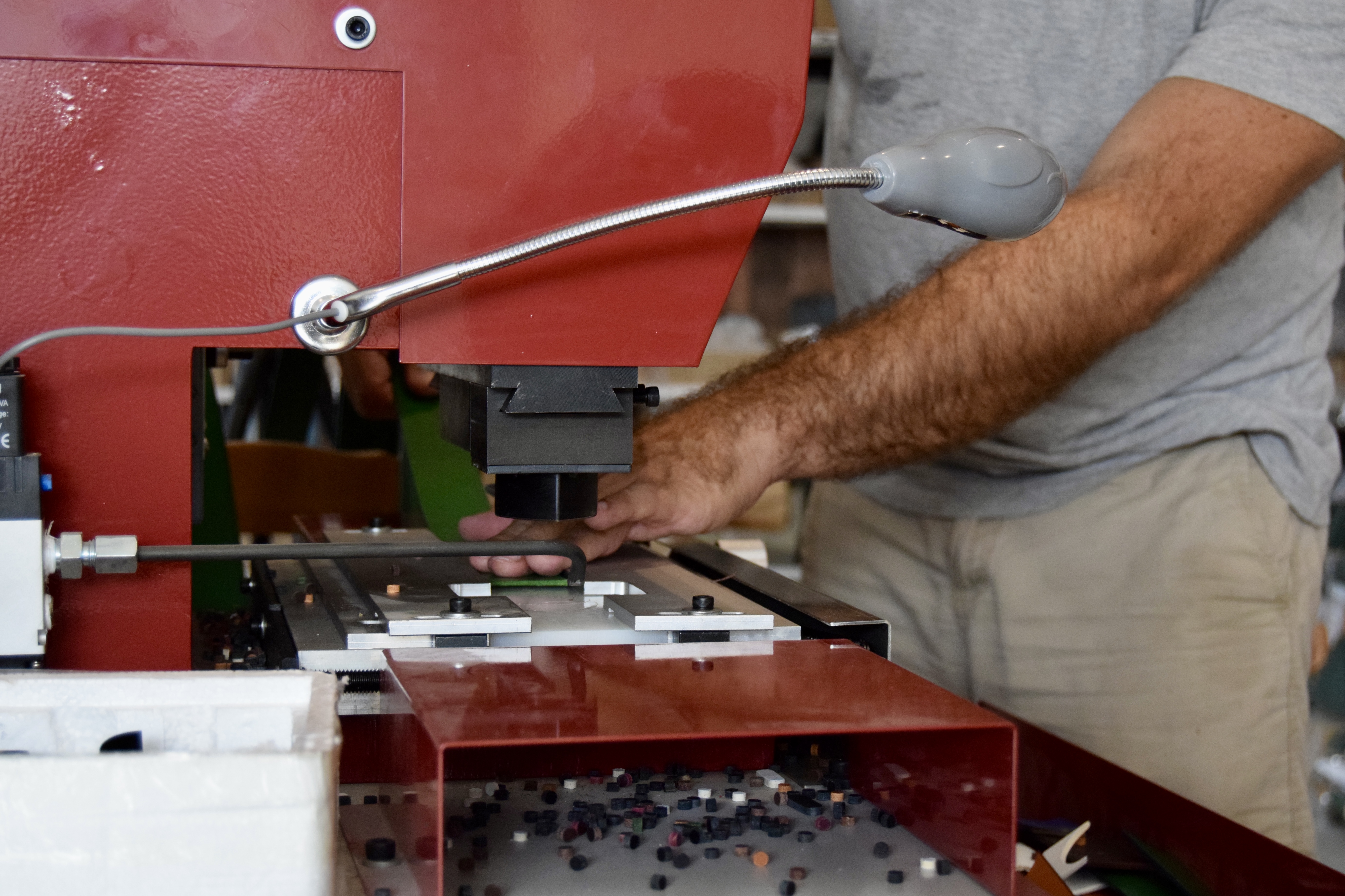Positionnement d'une sangle sous la presse à emporte-pièces avant la découpe de l'enchapure